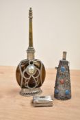A Moroccan style perfume bottle having brown colour glass mounted in an ornate silverplated case,