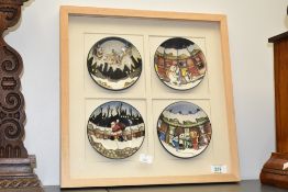 A set of 4 framed Moorcroft pottery Christmas pin dishes, painted makers mark to base, dates for