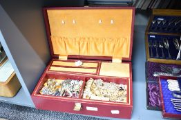 A large red faux leather jewellery box, containing an assortment of costume jewellery including