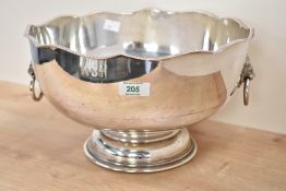 A silver plated punch bowl raised on a stout footed base, decorated with lion mask and ring handles,