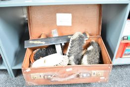 An early 20th century brown card suit case containing various brush heads, measuring tools, desk