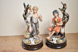 Two large vintage Capodimonte style figures depicting a male and female child amongst fruit trees,