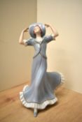 A Royal Dux hand painted porcelain figurine, depicting a lady in a large hat, measuring 23cm tall,