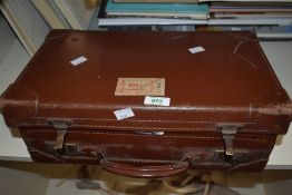 A small leather suitcase full of fly tying equipment including feathers, vices, cotton and tools