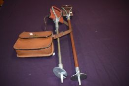 Two shooting sticks and a leather cartridge bag