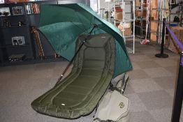 An on the bank seat /camp-bed, by NGT Specimen along with a large fishing umbrella and a rod carry