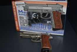 A Milbro M92 Rail CO2 .177 BB Air Pistol with brown pistol grip and serial number 18715080, in