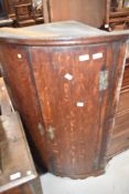 A 19th Century oak bow fronted corner cupboard, having bracket feet, height approx. 113cm