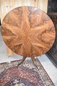 A 19th Century Regency style snap top breakfast table having sunburst veneered circular top on