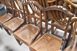 A set of four Regency style rail back dining chairs having canework seats and fluted legs