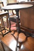 A 19th Century oak pedestal occasional table having circular top with turned column and triple splay