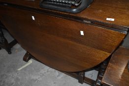 An early 20th Century dining table having narrow top and full length gatelegs