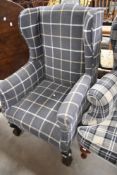A traditional wing back armchair having modern check upholstery and ball and claw feet