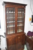 A 19th Century mahogany narrow bookcase with double cupboard under, height approx. 193cm