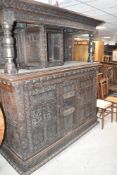 A large and impressive 18th Century oak court cupboard, profusely later carved and bearing date