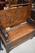 An early 20th Century oaks monks bench having typical carved decoration and lion arms, width approx.