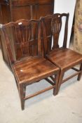 A pair of Georgian Hepplewhite style solid seat dining chairs