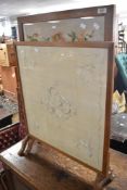 Two vintage golden oak firescreens having embroidered panels
