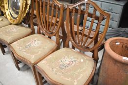 A set of four shield back dining chairs having drop in embroidered seats