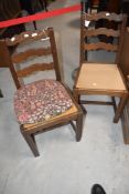 A pair of mid 20th Century oak dining chairs having shaped ladderbacks