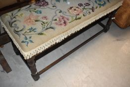 A traditional upholstered duet stool having turned oak frame
