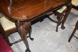 An early 20th Century mahogany drawer leaf dining table having shaped leg with ball and claw feet,