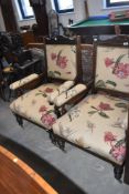 A pair of Victorian mahogany framed 'his and hers' style salon armchairs having later floral
