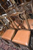 A set of four period oak Chippendale style dinig chairs having later vinyl drop in seats