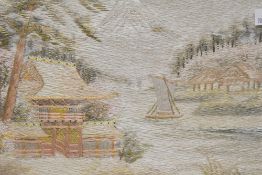 A pair of Japanese silk embroidered pictures, possibly 20th century, depicting forests and