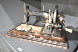 A late 19th / early 20th century Singer style sewing machine, supported on an ebonised wooden