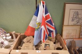 A collection of unpainted decorative plaques and houses and five small flags