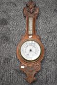 A Aneroid Barometer having temperature gauge in both Fahrenheit and centigrade, the oak case