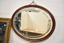 An oval sorcerer's mirror in a mahogany frame, consisting of 56 reverse circular optics, W66.5cm