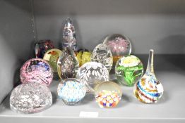 A group of fourteen mixed glass paperweights, to include millefiori, wheel engraved, lamp work,