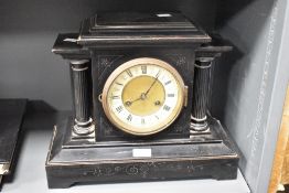A 19th century black 8 day mantel clock having black Roman numerals on a cream chapter ring with a