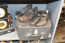 A pair of early 20th century leather clogs, sold together with a suit case, (3)