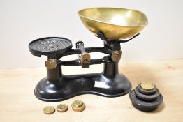 An early 20th century black cast iron weighing scale with weights, w25cm