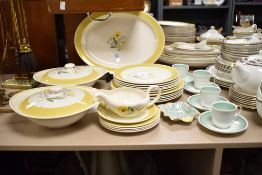 A Susie Cooper part dinner service, hand painted with floral designs and yellow border, comprising