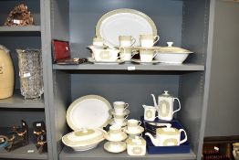 A Royal Doulton fine bone china dinner service, decorated with gilt edging and floral patterns on an