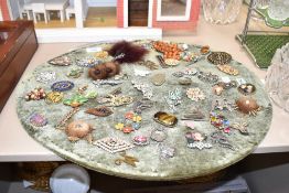 A large collection of costume brooches, including paste set examples, fur pieces and statement