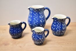 Local interest* A group of four Wetheriggs Pottery (Penrith) graduating slipware jugs, in blue