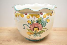 A large decorative continental pottery jardinieire, having a ruffled rim and decorated with S