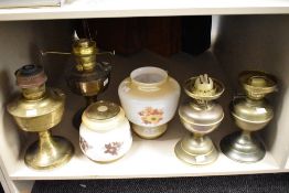 A brass vintage oil lamp with smoke glass shade decorated with foliage, largest h25cm, sold together