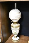 A Victorian brass and white porcelain oil lamp decorated with ferns and repeating borders, the
