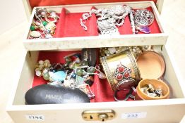 A cream faux leather jewellery box, containing a collection of costume jewellery including faux