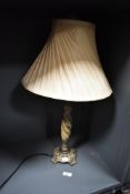 A modern decorative table lamp, of twisted form with quatrefoil base and flared material shade