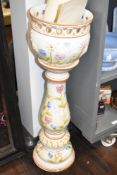 A large ceramic jardiniere having floral design to white background with off red detailing,