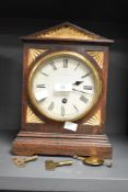 An early 20th century oak cased mantel clock, of architectural form with carved and gilded