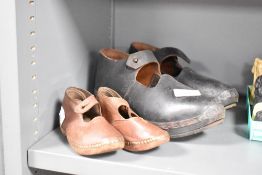 A pair of early 20th century brown leather clogs, L14.5cm, sold together with another pair of