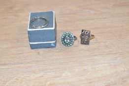 Three white metal rings, comprising a white sapphire full eternity band, a paste and marcasite set